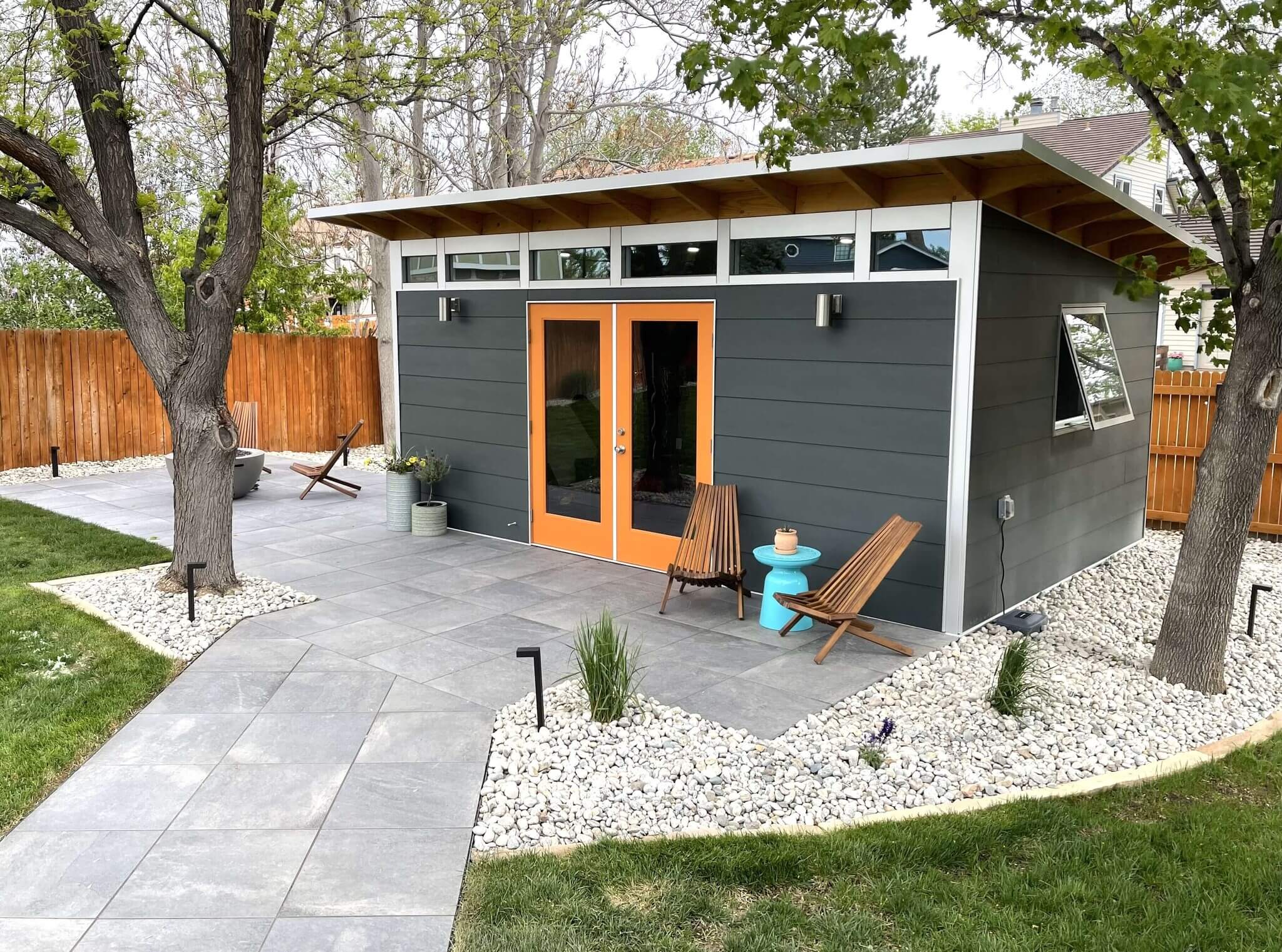 A modern Studio Shed ADU in a beautiful backyard setting at dusk.